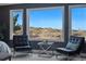 Bedroom chairs offer scenic views of the outdoors through bright, expansive windows at 6577 Esperanza Dr, Castle Pines, CO 80108