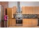 The kitchen features wooden cabinets, stainless steel appliances, and tile backsplash at 2955 Inca St # 2Q, Denver, CO 80202