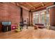 Open-concept living space with exposed brick, wood ceilings, and a modern workspace at 2955 Inca St # 2Q, Denver, CO 80202