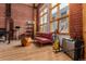 Bright living room with exposed brick walls, wooden ceilings, and large windows for natural light at 2955 Inca St # 2Q, Denver, CO 80202