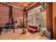 Spacious living room featuring exposed brick, wood floors and large windows providing an abundance of natural light at 2955 Inca St # 2Q, Denver, CO 80202