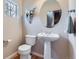 Powder bathroom features hardwood floors, pedestal sink, and a round mirror at 10148 E 29Th Dr, Denver, CO 80238