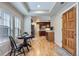 Bright dining area features hardwood floors, a dining table, and a view of the kitchen with cherry cabinets at 10148 E 29Th Dr, Denver, CO 80238