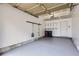 Clean garage with painted floor, ceiling storage, wall-mounted utility hangers, and built-in shelves at 10148 E 29Th Dr, Denver, CO 80238