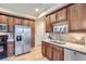 Bright kitchen features stainless steel appliances, wood cabinets, and dual basin sink at 10148 E 29Th Dr, Denver, CO 80238