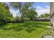 View of the backyard with mature trees, lawn, and partial fencing at 1742 S Forest St, Denver, CO 80222