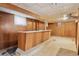 Basement featuring a built-in bar with retro wood paneling and tile flooring at 1742 S Forest St, Denver, CO 80222