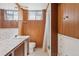 Bathroom with paneled walls and vanity sink with shower/tub combo at 1742 S Forest St, Denver, CO 80222