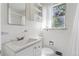 Bright bathroom featuring white tile, a built-in sink vanity and a window offering natural light at 1742 S Forest St, Denver, CO 80222