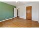 Bedroom with hardwood floors, green accent wall, standard closet and a white ceiling fan at 1742 S Forest St, Denver, CO 80222