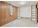 Bedroom featuring paneled walls, overhead lighting, and built-in shelving at 1742 S Forest St, Denver, CO 80222