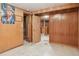 Basement hallway with paneled walls and view of finished room with built-in bar at 1742 S Forest St, Denver, CO 80222