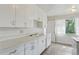 Charming kitchen featuring white cabinets and a bright window at 1742 S Forest St, Denver, CO 80222