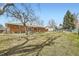 Spacious backyard with mature trees, brick house and detached garage at 2822 S Zenobia St, Denver, CO 80236