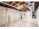 Unfinished basement with exposed ceiling, concrete walls, utility sink and tile flooring at 2822 S Zenobia St, Denver, CO 80236