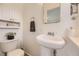 Well-lit bathroom with modern fixtures, a pedestal sink, and classic white fixtures at 2822 S Zenobia St, Denver, CO 80236