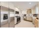 Modern kitchen boasts stainless steel appliances, white cabinets, and ample counter space at 2822 S Zenobia St, Denver, CO 80236