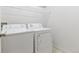 Small laundry room with a washer, dryer, and wire shelving above at 30 Garfield St # G, Denver, CO 80206