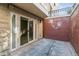 Exterior shot of patio with concrete floor, brick wall and sliding glass doors at 30 Garfield St # G, Denver, CO 80206