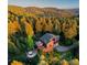 Beautiful mountain home with a deck and hot tub, nestled among lush, colorful trees and foliage at 13416 Kuehster Rd, Littleton, CO 80127
