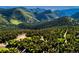 Stunning aerial view showcasing a home nestled among lush green mountains and dense forests, offering privacy and serenity at 13416 Kuehster Rd, Littleton, CO 80127
