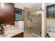 Bathroom featuring a glass enclosed shower, granite counters, dark wood cabinets, and a rustic ambiance at 13416 Kuehster Rd, Littleton, CO 80127