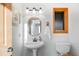 Bathroom featuring a pedestal sink, framed mirror, natural lighting, and modern fixtures at 13416 Kuehster Rd, Littleton, CO 80127