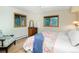 Bright bedroom with wood floors, dresser, ceiling fan, and two windows offering natural light and views at 13416 Kuehster Rd, Littleton, CO 80127