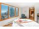 Cozy bedroom featuring hardwood floors, large window with outside views, and a warm inviting decor at 13416 Kuehster Rd, Littleton, CO 80127
