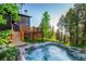 Relaxing hot tub adjacent to a deck with outdoor furniture, surrounded by mature trees at 13416 Kuehster Rd, Littleton, CO 80127