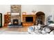 Comfortable living room featuring stone fireplace, wood floors, and seamless flow to adjacent areas, for cozy living at 13416 Kuehster Rd, Littleton, CO 80127