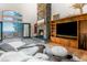 Bright living room with stone fireplace, wood built-ins, and sliding doors to the deck at 13416 Kuehster Rd, Littleton, CO 80127