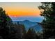 Scenic sunset view of mountains and valleys, framed by trees creating a tranquil and picturesque atmosphere at 13416 Kuehster Rd, Littleton, CO 80127