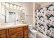 Well-lit bathroom with a modern vanity, a floral shower curtain, and decorative wall art at 10818 Cimarron St # 1202, Firestone, CO 80504