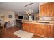 Well-lit kitchen area with wood cabinets, stainless steel dishwasher and pass-through counter into living room at 10818 Cimarron St # 1202, Firestone, CO 80504