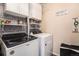 Efficient laundry room with modern washer and dryer, storage cabinets, and decorative shelving at 10818 Cimarron St # 1202, Firestone, CO 80504