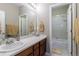 Bathroom featuring wood cabinets and countertop, sink, mirror, and shower with bathtub at 6265 S Ider Way, Aurora, CO 80016