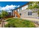 Exterior view of stone-faced building with green grass and wooden stairs at 6265 S Ider Way, Aurora, CO 80016
