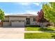 Charming single-story home with stone accents, three-car garage, and well-manicured lawn at 6265 S Ider Way, Aurora, CO 80016