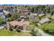 Expansive aerial view of a home with mature landscaping, nestled in a green, well-spaced neighborhood with mountain views at 2837 Reed St, Wheat Ridge, CO 80033