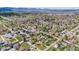 An expansive aerial view of the neighborhood with various homes, mature trees, and green lawns with mountain views at 2837 Reed St, Wheat Ridge, CO 80033