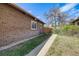 View of the side yard showcasing the home's brick exterior at 2837 Reed St, Wheat Ridge, CO 80033