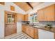 Charming kitchen with wooden cabinets, granite countertops, stainless steel sink, and tile flooring at 2837 Reed St, Wheat Ridge, CO 80033