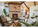 Inviting living room boasts a striking stone fireplace, wood ceiling, and comfortable seating at 2837 Reed St, Wheat Ridge, CO 80033
