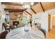 Open floorplan blending the dining area and living room with wood ceilings and stone fireplace at 2837 Reed St, Wheat Ridge, CO 80033