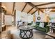 Open-concept living room with wood ceilings, a stone fireplace, and stylish, comfortable furnishings at 2837 Reed St, Wheat Ridge, CO 80033