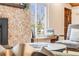 Tastefully decorated living room showcasing a stone fireplace, window seating, and modern decor at 2837 Reed St, Wheat Ridge, CO 80033