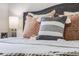 Detailed shot of decorative pillows on a cozy bed with a stylish headboard and a side table lamp at 2837 Reed St, Wheat Ridge, CO 80033