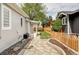 Picturesque backyard with stone walkway, lush greenery, and privacy fencing with planting beds at 3365 S Grant St, Englewood, CO 80113
