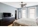 A cozy bedroom features light blue walls, hardwood floors, and a ceiling fan with lights at 3365 S Grant St, Englewood, CO 80113